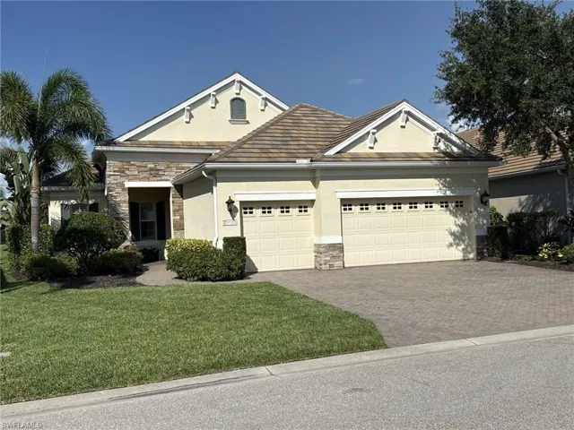 Stucco exterior with stone accents and a patterned tile roof