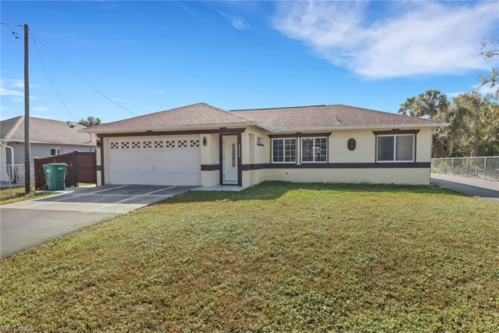Single story home with concrete driveway, fence, a garage, and stucco siding