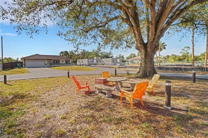 View of yard with an attached garage, fence, and driveway