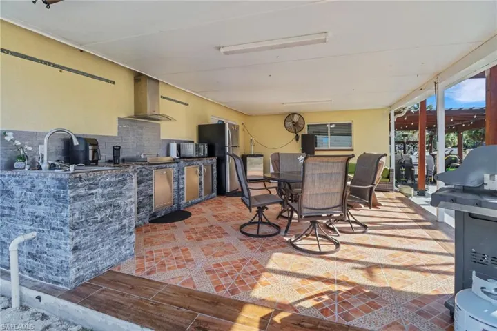 View of patio / terrace with area for grilling, a sink, and outdoor dining area