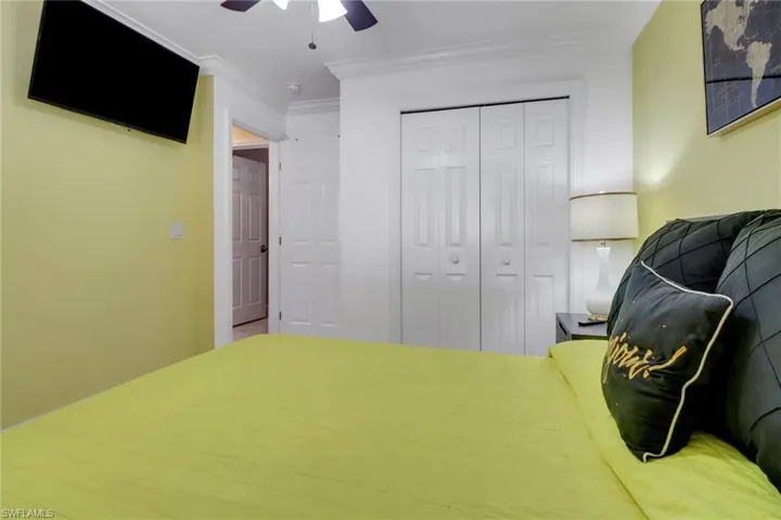 Bedroom featuring ornamental molding, a ceiling fan, and a closet