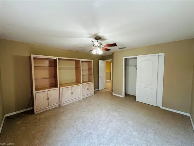 Unfurnished bedroom with a closet, carpet floors, and ceiling fan