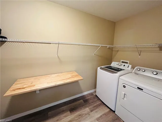 Laundry room featuring light wood-style floors and washing machine and dryer