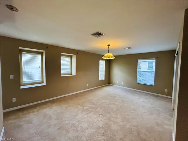 Empty room featuring baseboards and light carpet
