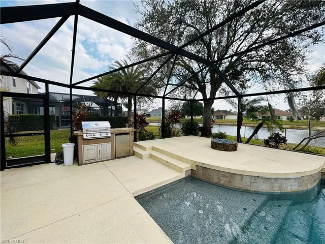 Outdoor pool with a lanai, a patio, an outdoor kitchen, and a sunroom