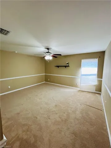 Unfurnished room with a ceiling fan and light colored carpet