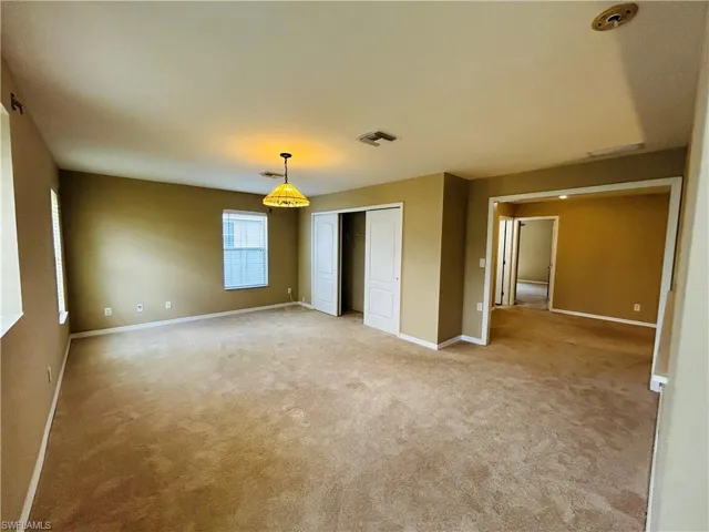 Unfurnished bedroom featuring a closet and light carpet