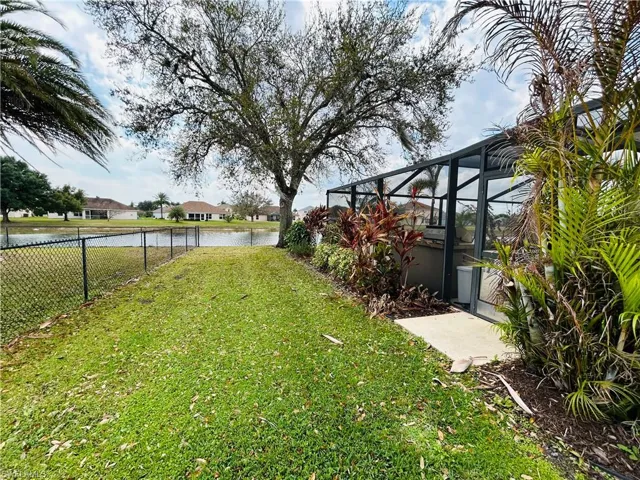 View of yard with a sunroom, a water view, glass enclosure, and a residential view