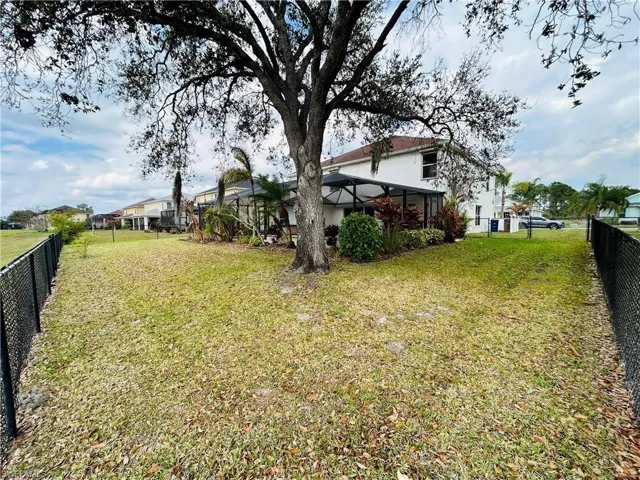 Fenced backyard with a residential view and a lanai