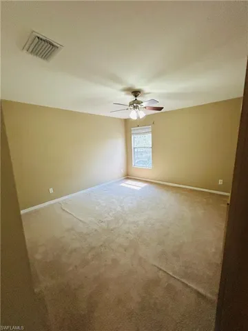 Carpeted spare room with a textured ceiling and a ceiling fan