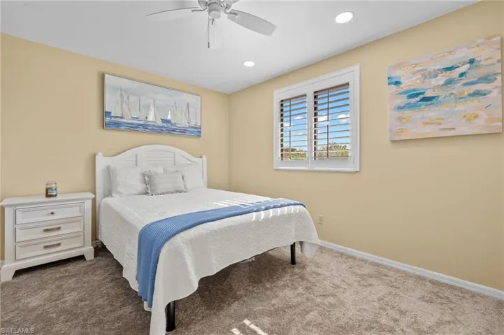 Carpeted bedroom featuring ceiling fan