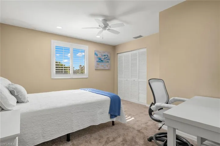 Carpeted bedroom featuring a closet and ceiling fan