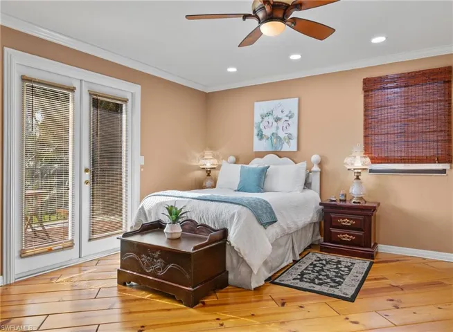Bedroom with ornamental molding, wood-type flooring, access to outside, and ceiling fan