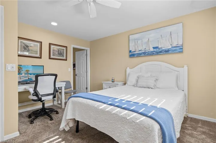 Carpeted bedroom featuring ceiling fan