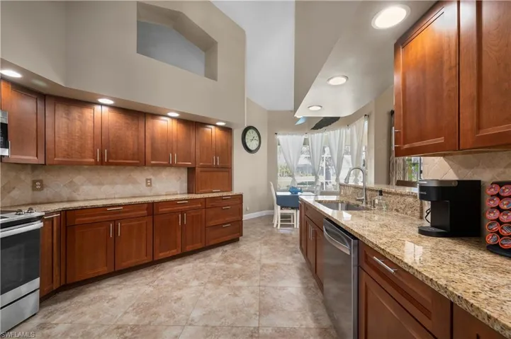 Kitchen featuring stainless steel appliances, a sink, and brown cabinets