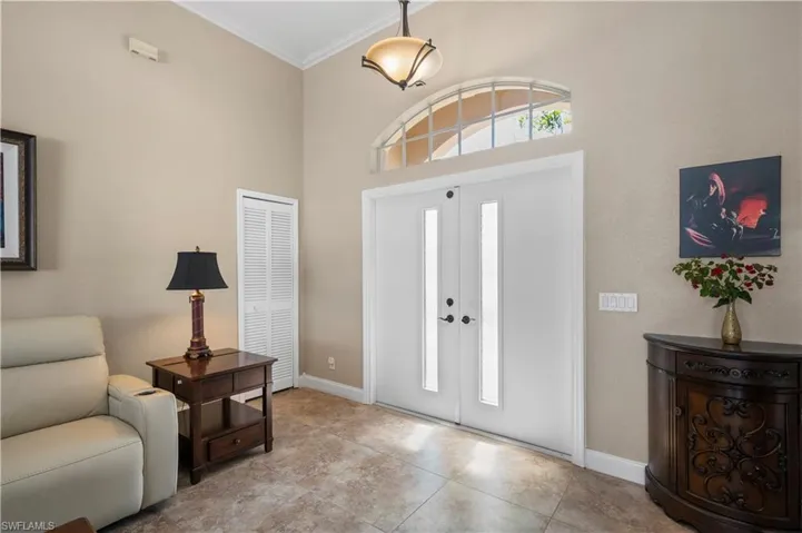 Tiled foyer entrance featuring baseboards, french doors, a high ceiling, and crown molding