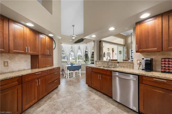 Kitchen with dishwasher, a peninsula, brown cabinetry, and a sink
