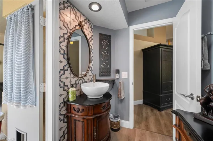 Bathroom featuring wood finished floors, vanity, and baseboards