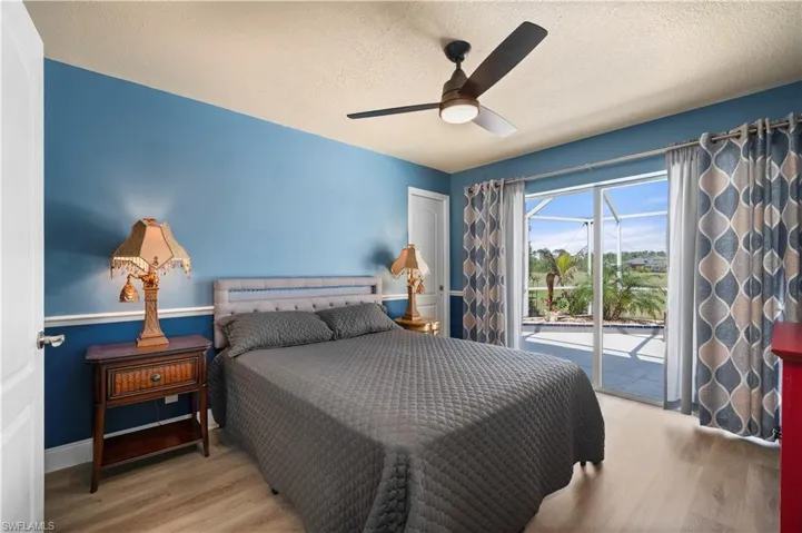 Bedroom featuring a textured ceiling, access to outside, wood finished floors, and a ceiling fan