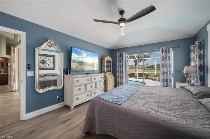 Bedroom featuring access to exterior, a ceiling fan, a textured ceiling, wood finished floors, and baseboards