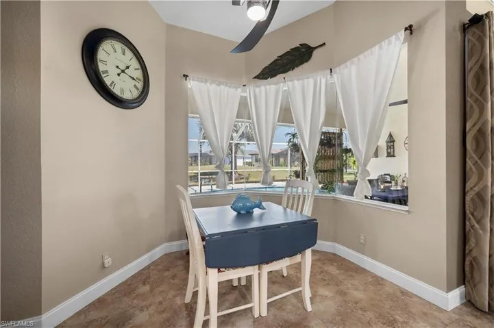 Dining room with tile patterned flooring, ceiling fan, and baseboards