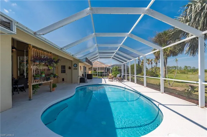 Pool featuring glass enclosure and a patio area