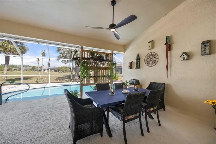 View of patio / terrace featuring a lanai, outdoor dining area, ceiling fan, and an outdoor pool