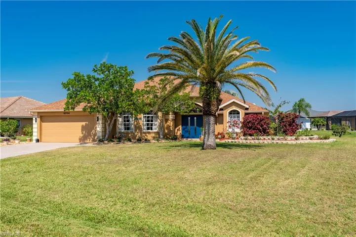 View of front of house with an attached garage, stucco siding, concrete driveway, and a front yard