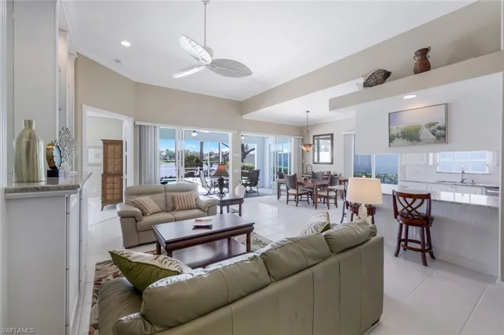 Living room featuring ornamental molding, ceiling fan, light tile patterned floors, plenty of natural light, and recessed lighting