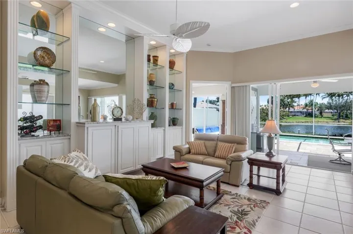 Living area with ornamental molding, light tile patterned floors, ceiling fan, built in shelves, and recessed lighting