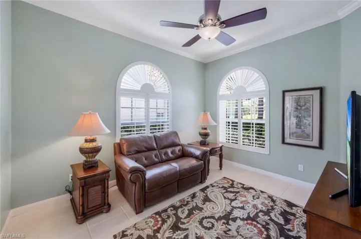 Living room featuring healthy amount of natural light, ornamental molding, tile patterned flooring, baseboards, and ceiling fan