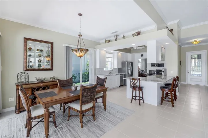 Dining space with ornamental molding, light tile patterned floors, ceiling fan, and baseboards