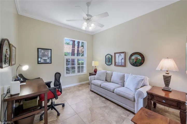 Office space featuring crown molding, ceiling fan, baseboards, and light tile patterned floors