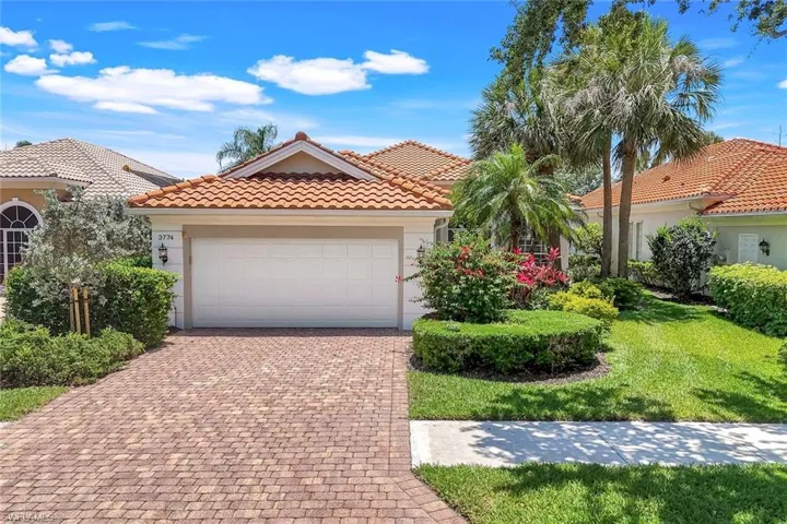 Mediterranean / spanish home featuring stucco siding, decorative driveway, a tiled roof, a garage, and a front yard