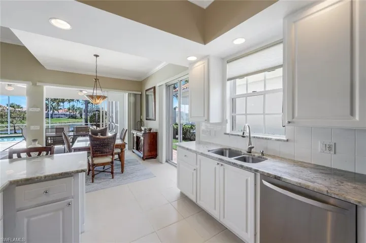 Kitchen featuring a sink, dishwasher, crown molding, white cabinets, and decorative backsplash
