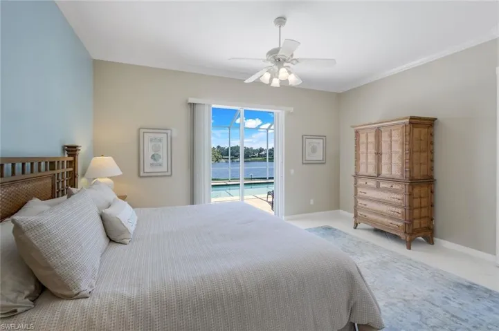 Bedroom with access to outside, ornamental molding, ceiling fan, baseboards, and a water view