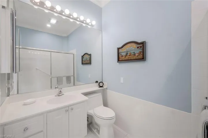 Bathroom with toilet, a shower stall, crown molding, and vanity