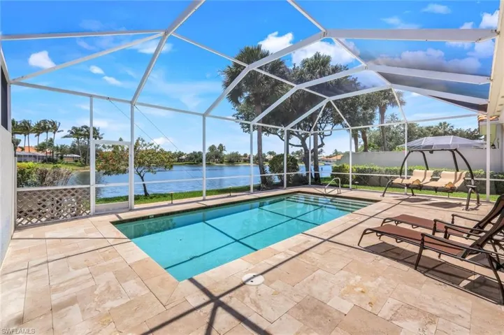 Swimming pool featuring a water view, a patio area, and a lanai