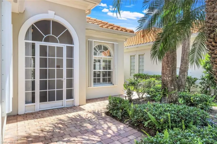 Entrance to property with stucco siding, a patio, and a tile roof
