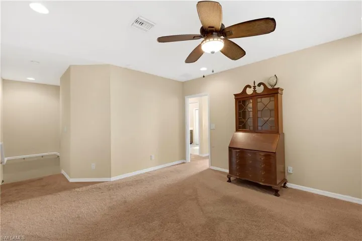 Empty room with light colored carpet and ceiling fan