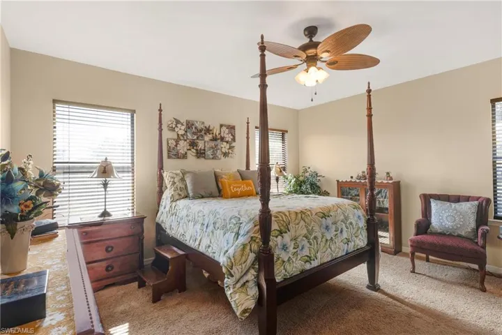 Carpeted bedroom featuring ceiling fan