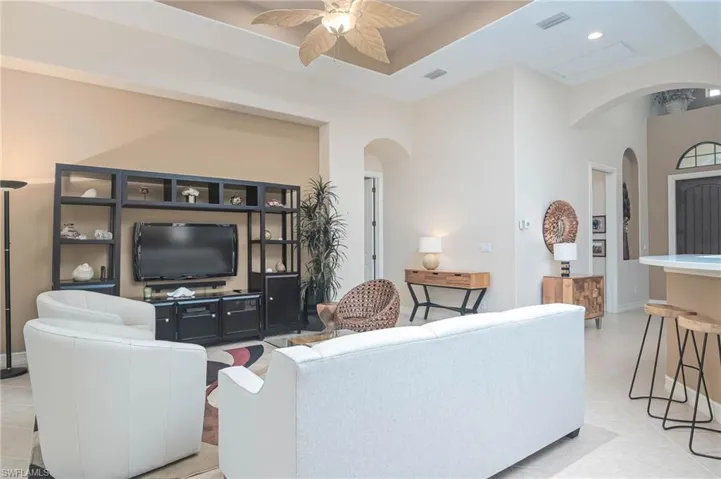Living room with ceiling fan and light tile patterned flooring