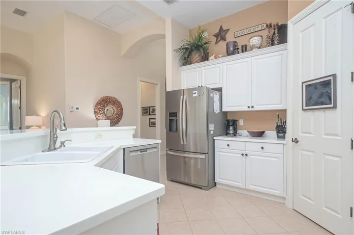 Kitchen featuring appliances with stainless steel finishes, white cabinetry, sink, and light tile patterned flooring