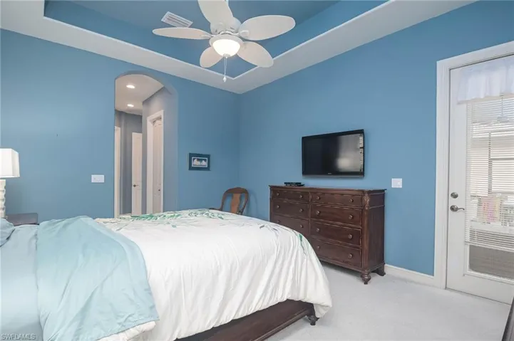 Carpeted bedroom featuring ceiling fan