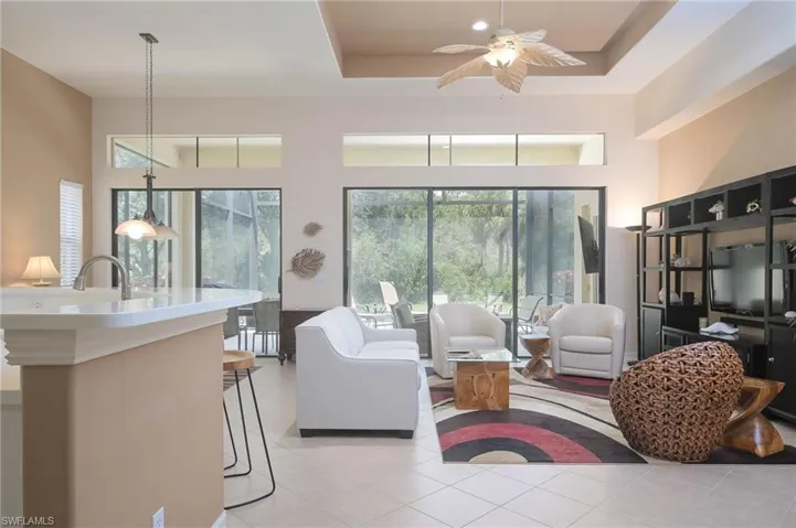 Tiled living room with a raised ceiling and ceiling fan