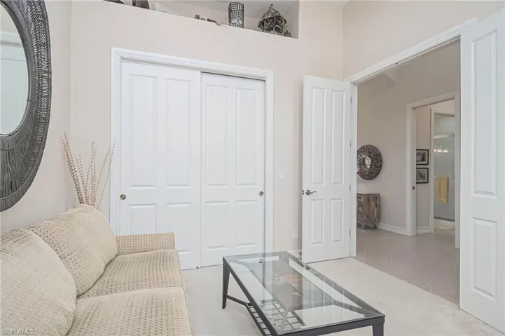 Living area with a high ceiling and light tile patterned flooring