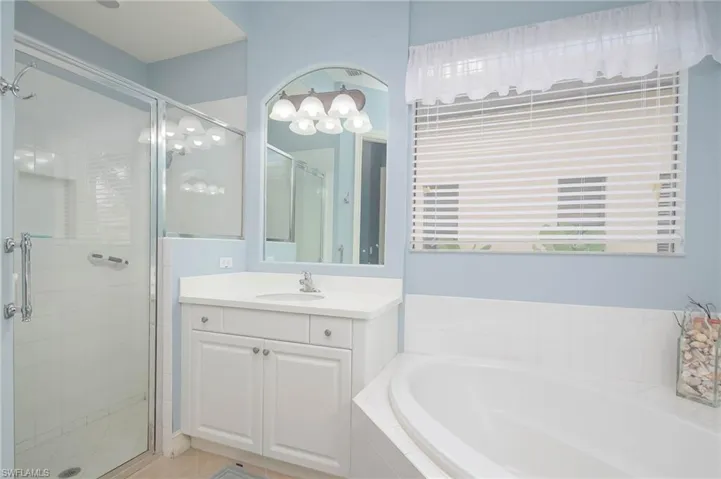 Bathroom with vanity, separate shower and tub, and tile patterned floors