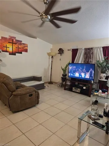 Living room with light tile patterned flooring and a textured ceiling