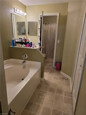Bathroom featuring tile patterned flooring and separate shower and tub