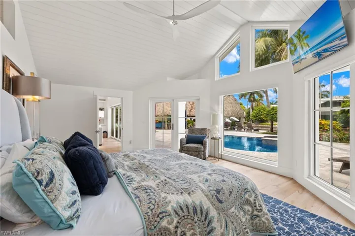 Bedroom with high vaulted ceiling and light wood-type flooring